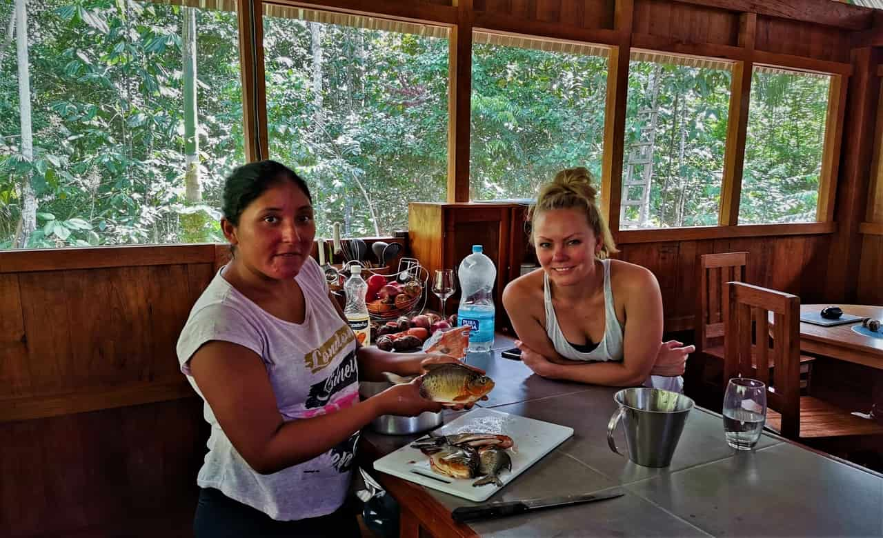 Traveler and family member Esmeralda cooking fish in the jungle bungalow