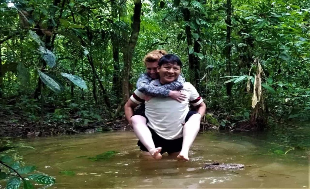 Travelers crossing a river while exploring the jungle