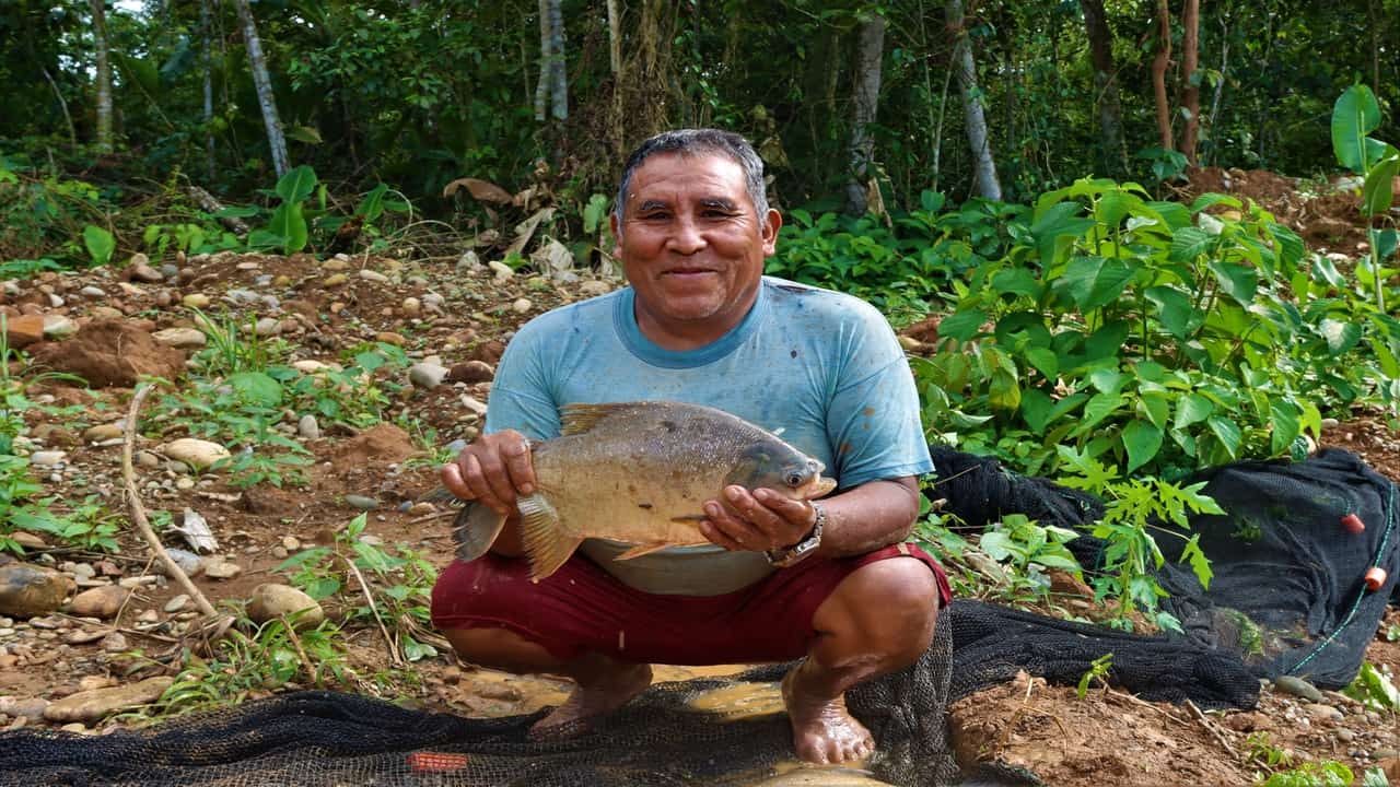 Family member Cayetano Llaqui holding a Paco fish