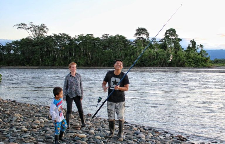 A family fishes on the riverbanks near Nuevo Eden